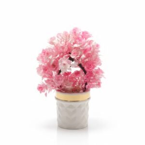 Preserved pink flower arrangement in white pot.